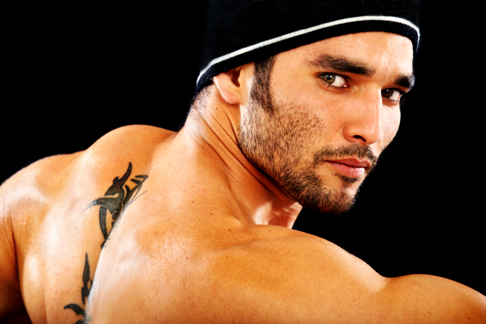 masculine man portrait staring at the camera isolated over a black background